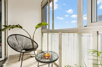 a balcony with a glass table and chairs and a window at Apartamento cerca de la playa in Barcelona