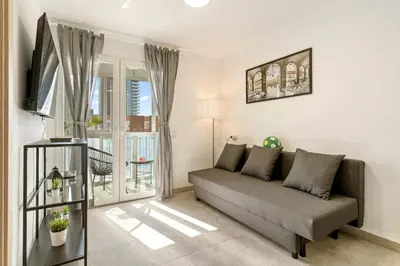 a living room with a couch and a window at Apartamento cerca de la playa in Barcelona