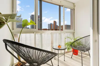 a room with two chairs and a large window at Apartamento cerca de la playa in Barcelona