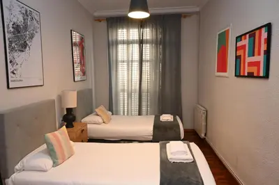 a hotel room with two beds and a window at Homenfun Barcelona Las Ramblas in Barcelona
