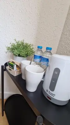 a counter with a mixer and bowls and bottles of water at Barcelona PR Guesthouse in El Prat de Llobregat
