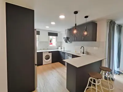 a kitchen with black and white cabinets and a kitchen island at Fantastic apartment Sant Adria Beach in Sant Adria de Besos