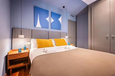 a bedroom with a large bed with yellow and blue at Sweett - Casa Roma in Barcelona