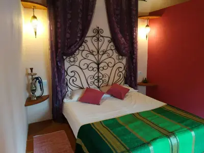 a bedroom with a bed with a large headboard at Mas Can Puig de Fuirosos ONLY ADULTS in La Batlloria