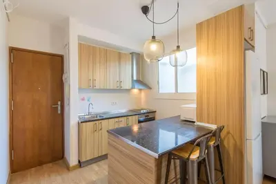 a kitchen with wooden cabinets and a counter top at BeBarceloner Sant Andreu Apartments - Studio in Barcelona