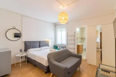 a bedroom with a bed and a chair at BeBarceloner Sant Andreu Apartments - Studio in Barcelona