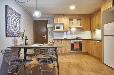 a kitchen with wooden cabinets and a table and chairs at BeBarceloner Sant Andreu Apartments - 1 bedroom in Barcelona