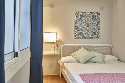 a small bedroom with a bed with a window at BeBarceloner Sant Andreu Apartments - 1 bedroom in Barcelona