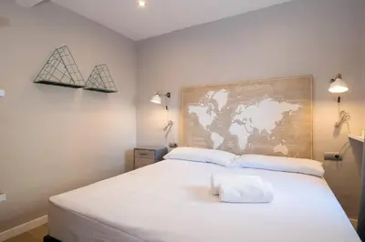 a bedroom with a white bed with a map on the wall at BeBarceloner Sant Andreu Apartments - 3 bedrooms with terrace in Barcelona