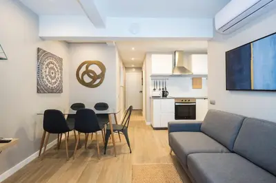 a living room with a couch and a table and chairs at BeBarceloner Sant Andreu Apartments - 3 bedrooms with terrace in Barcelona
