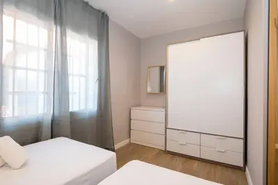 a bedroom with two beds and a dresser and a mirror at BeBarceloner Sant Andreu Apartments - 3 bedrooms with terrace in Barcelona