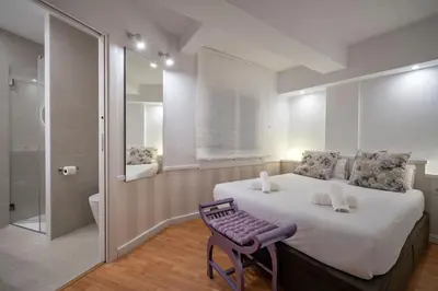 a bedroom with a large bed and a purple chair at Habitat Apartments Ribes in Barcelona