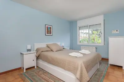 a bedroom with a bed with blue walls and a window at HHBCN Beach Apartment Castelldefels #3 in Castelldefels