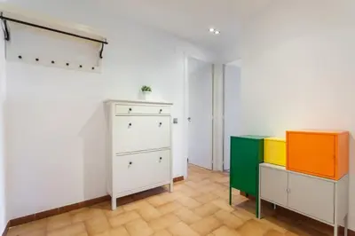 a room with white cabinets and colorful furniture at HHBCN Beach Apartment Castelldefels #3 in Castelldefels