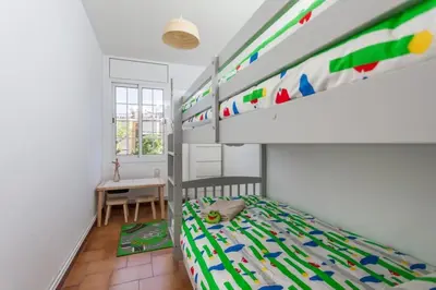 a bedroom with a bunk bed and a desk at HHBCN Beach Apartment Castelldefels #3 in Castelldefels