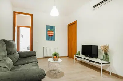 a living room with a couch and a tv at The Collection Barcelona - Comfortable 3BD in Poblenou next to the beach only for Families! in Barcelona