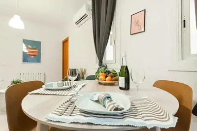a table with a plate of fruit and a bottle of wine at The Collection Barcelona - Comfortable 3BD in Poblenou next to the beach only for Families! in Barcelona