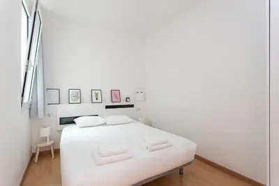 a white bedroom with a white bed with white sheets at The Collection Barcelona - 3BD only for Families in Poblenou next to the beach! in Barcelona