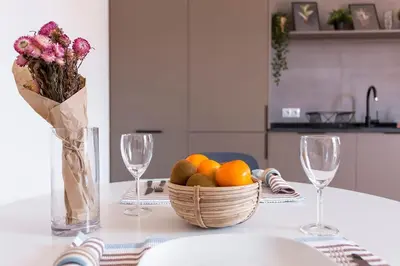 a table with a basket of fruit and two wine glasses at The Collection Barcelona - 3BD only for Families in Poblenou next to the beach! in Barcelona