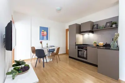 a kitchen and living room with a table and chairs at The Collection Barcelona - Sunny 3BD only for Families in Poblenou next to the sea! in Barcelona