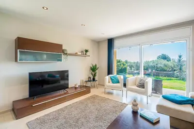 a living room with a large flat screen tv at Winahost Casa familiar con piscina in Santa Eulalia de Ronsaná