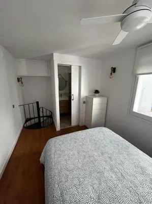 a white bedroom with a bed and a window at Marina Beach Aiguadolç Sitges in Sitges