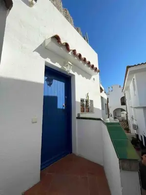 a blue door on the side of a white building at Marina Beach Aiguadolç Sitges in Sitges