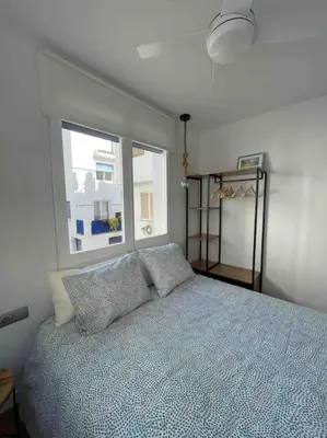a bedroom with a bed with pillows and a window at Marina Beach Aiguadolç Sitges in Sitges