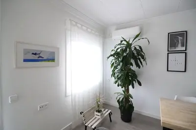a white room with a plant and a bench at Nice new apartment only 30min to Barcelona center. in Granollers