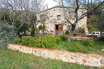 a stone house with trees in front of it at MASIA CAN SUNYER AGROTURISMO in La Garriga