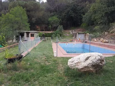 a fence around a swimming pool in a yard at MASIA CAN SUNYER AGROTURISMO in La Garriga