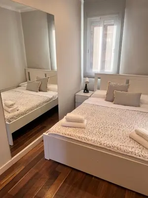 two beds in a room with a mirror at Ca la Noa in Viladecáns