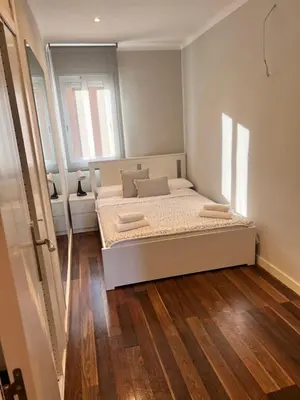 a small bedroom with a bed and a mirror at Ca la Noa in Viladecáns