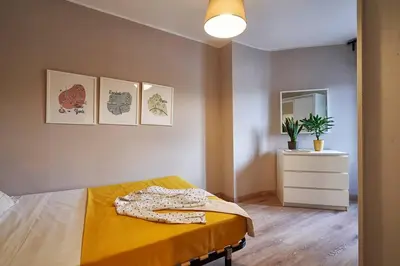 a bedroom with a bed with a yellow blanket and a dresser at BeBarceloner Sant Andreu Apartments - 3 bedrooms in Barcelona