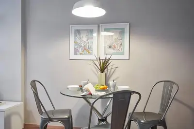 a table with chairs and a bowl of fruit on it at BeBarceloner Sant Andreu Apartments - 3 bedrooms in Barcelona