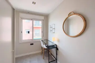 a mirror and a desk in a room with a window at BeBarceloner Sant Andreu Apartments - 3 bedrooms in Barcelona