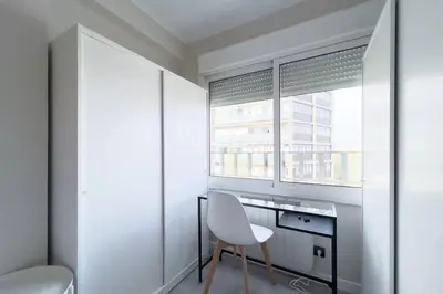 a white chair in a room with a window at BeBarceloner Sant Andreu Apartments - 3 bedrooms in Barcelona