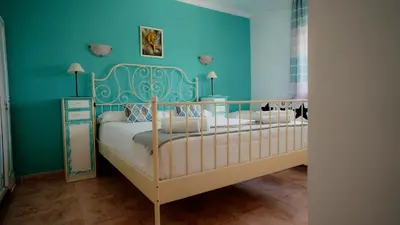 a bedroom with two beds and a blue wall at La Casa de Mima in Cubelles