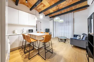 a kitchen and living room with a table and chairs at BeBarceloner Eixample Apartments in Barcelona