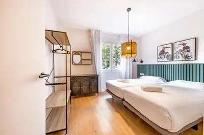 a bedroom with two beds and a window at BeBarceloner Eixample Apartments in Barcelona