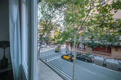 a window view of a street with a yellow taxi at BeBarceloner Eixample Apartments in Barcelona