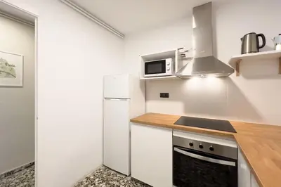 a kitchen with a white refrigerator and a microwave at BeBarceloner Eixample Apartments - 3 bedrooms in Barcelona
