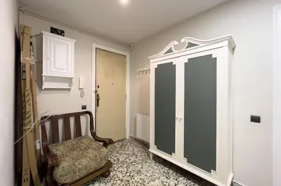 a room with a chair and a cabinet in it at BeBarceloner Eixample Apartments - 3 bedrooms in Barcelona