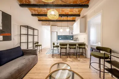 a living room with a couch and a table with chairs at BeBarceloner Eixample Apartments - 4 bedrooms in Barcelona