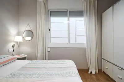 a bedroom with a bed and a large window at BeBarceloner Eixample Apartments - 2 bedrooms in Barcelona