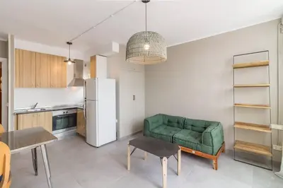 a kitchen with a green couch and a refrigerator at BeBarceloner Sant Andreu Apartments - Attic with terrace in Barcelona