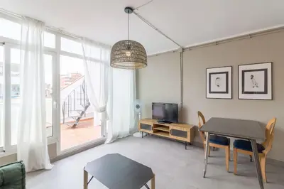a living room with a table and a television at BeBarceloner Sant Andreu Apartments - Attic with terrace in Barcelona