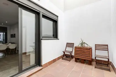 a room with two chairs and a table and windows at Urban Flats Vallirana in Barcelona
