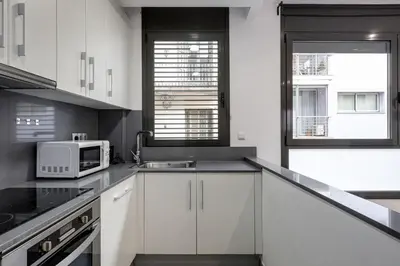 a kitchen with white cabinets and a microwave at Urban Flats Vallirana in Barcelona