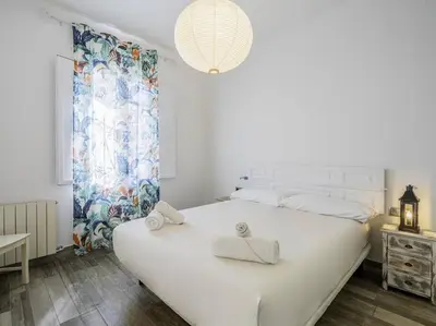 a bedroom with a large white bed with towels on it at Casa Mediterránea en Badalona in Badalona